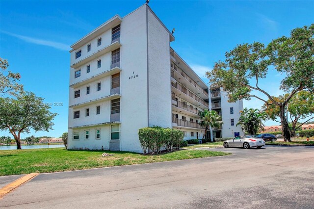 8720 N Sherman Cir Unit 401, Miramar, FL 33025 - view of apartment building / complex featuring a water view and uncovered parking