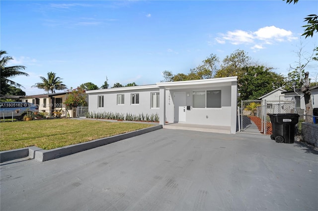 manufactured / mobile home featuring stucco siding, driveway, and a gate