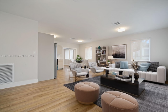living area with light wood-style floors and baseboards