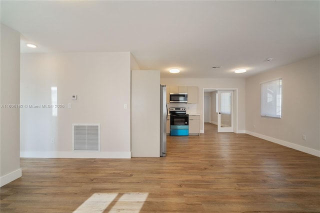 unfurnished living room with baseboards and light wood finished floors