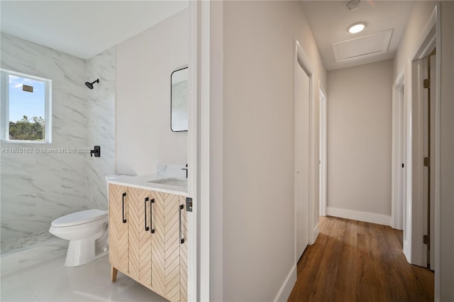 full bathroom with a marble finish shower, vanity, toilet, baseboards, and wood finished floors