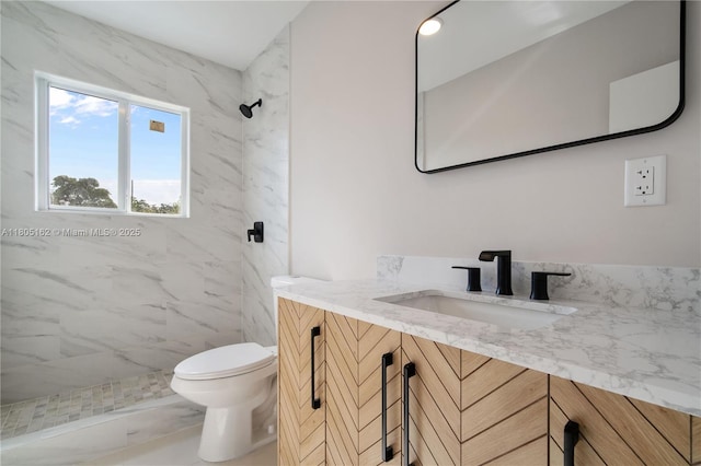 full bath featuring a marble finish shower, toilet, and vanity