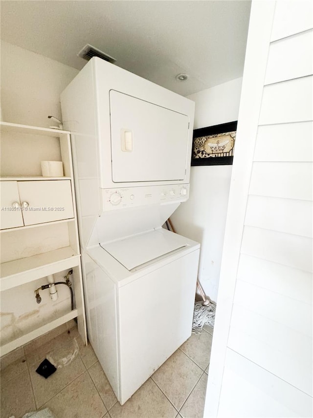 2025 NE 164th St Unit 206, North Miami Beach, FL 33162 - washroom with estacked washer and dryer and light tile patterned floors