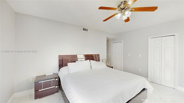 931 SW 11th St Unit H-1, Miami, FL 33129 - bedroom with light marble finish flooring, two closets, ceiling fan, and baseboards
