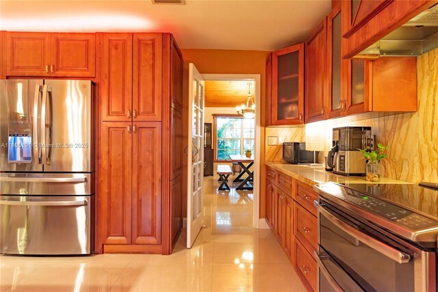 15332 SW 142nd Ter, Miami, FL 33196 - kitchen featuring appliances with stainless steel finishes, range hood, light tile patterned flooring, glass insert cabinets, and a chandelier
