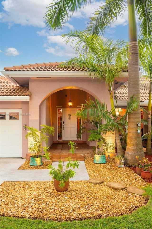 15332 SW 142nd Ter, Miami, FL 33196 - property entrance featuring a tiled roof, stucco siding, a garage, and driveway