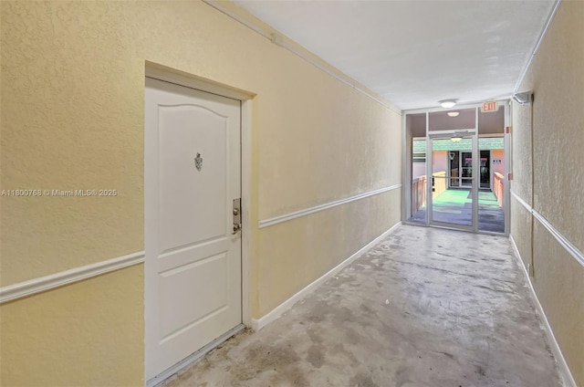 760 SE 2nd Ave Unit G206, Deerfield Beach, FL 33441 - hallway featuring unfinished concrete floors and a textured wall