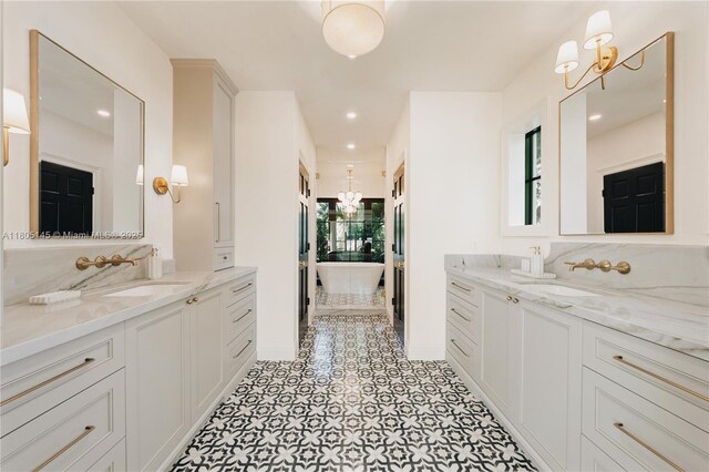 549 NE 59th St, Miami, FL 33137 - full bathroom featuring a chandelier, two vanities, recessed lighting, baseboards, and tile patterned flooring