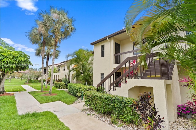 view of property's community featuring a lawn and stairway