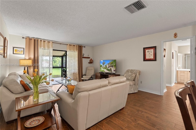 living room with a textured ceiling, wood finished floors, and baseboards