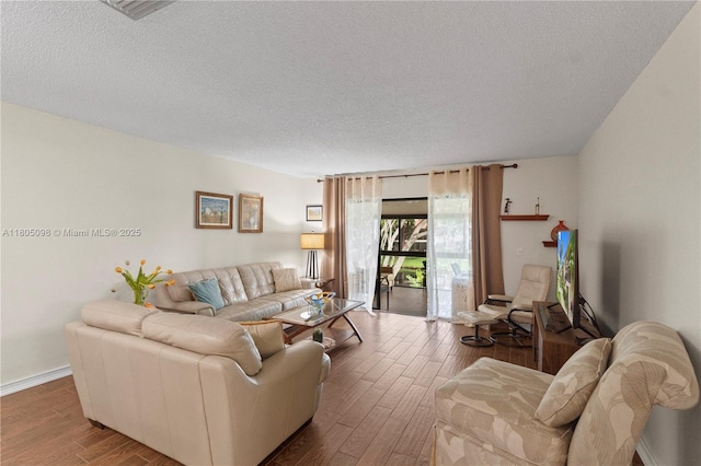 living area featuring a textured ceiling and wood finished floors