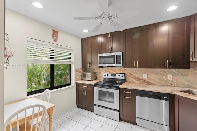 kitchen with stainless steel appliances, decorative backsplash, dark brown cabinetry, light tile patterned floors, and a ceiling fan