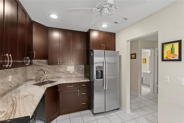 kitchen featuring stainless steel refrigerator with ice dispenser, a sink, ceiling fan, light tile patterned floors, and light stone countertops