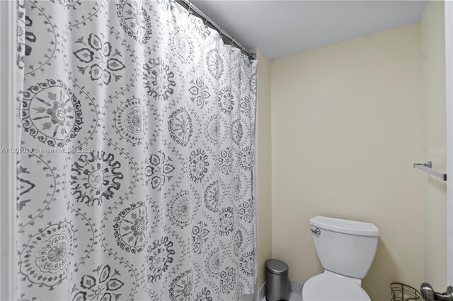 bathroom featuring toilet and a shower with shower curtain