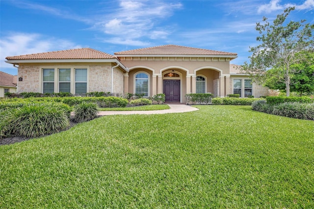 5474 S Sterling Ranch Cir, Davie, FL 33314 - mediterranean / spanish home featuring a front lawn, stone siding, a tiled roof, and stucco siding