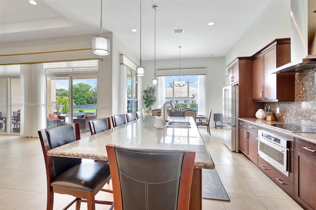 5474 S Sterling Ranch Cir, Davie, FL 33314 - kitchen with appliances with stainless steel finishes, a sink, wall chimney exhaust hood, a kitchen breakfast bar, and recessed lighting