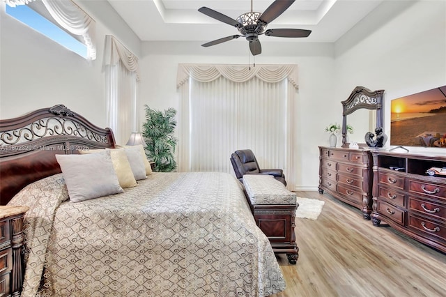 5474 S Sterling Ranch Cir, Davie, FL 33314 - bedroom with light wood-style flooring, a raised ceiling, and a ceiling fan