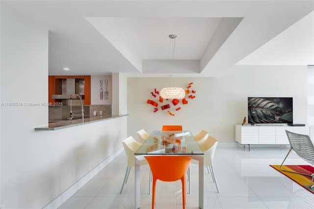tiled dining space with a chandelier, baseboards, a tray ceiling, and recessed lighting