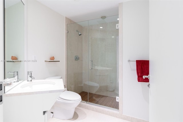 bathroom with toilet, a stall shower, and vanity