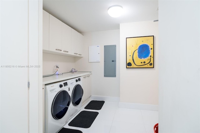 laundry area featuring washing machine and dryer, electric panel, cabinet space, and baseboards