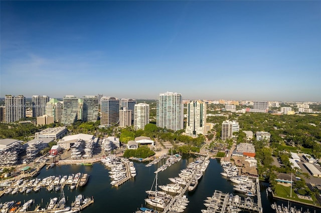 aerial view of property's location with a marina, nearby urban area, and a nearby body of water