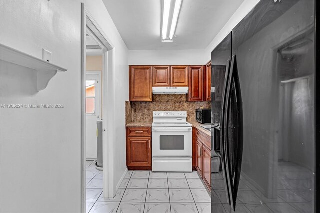 7612 NW 68th Ave, Tamarac, FL 33321 - kitchen with black refrigerator with ice dispenser, white electric range, under cabinet range hood, light countertops, and tasteful backsplash