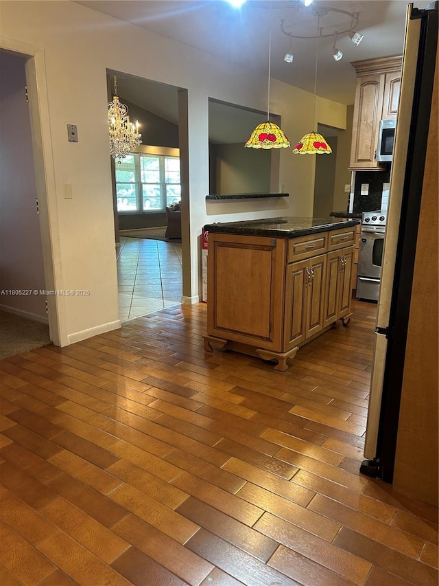 8631 Bridle Path Ct, Davie, FL 33328 - kitchen with stainless steel appliances, a chandelier, dark wood-style flooring, baseboards, and dark countertops