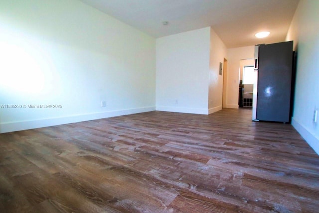 empty room featuring wood finished floors and baseboards
