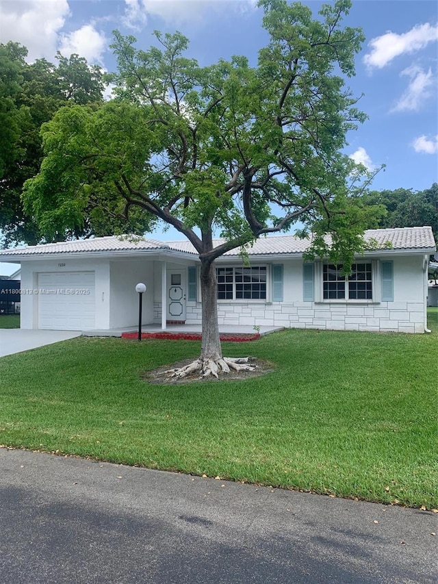 single story home with a front yard, a garage, concrete driveway, and stucco siding