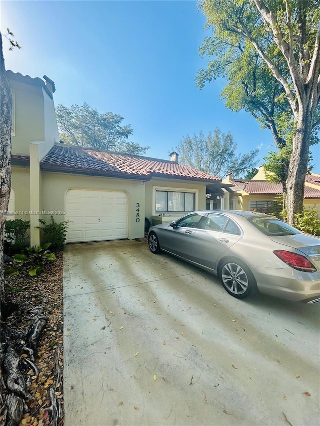3480 Torremolinos Ave Unit A-33, Doral, FL 33178 - view of front of house featuring a garage, concrete driveway, stucco siding, and a tiled roof