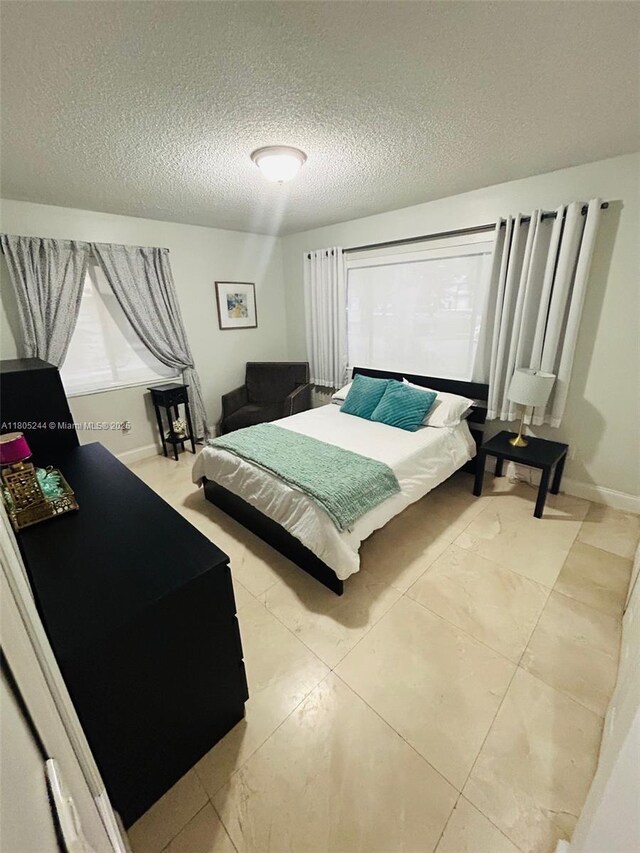 3480 Torremolinos Ave Unit A-33, Doral, FL 33178 - bedroom featuring a textured ceiling, baseboards, and light tile patterned flooring