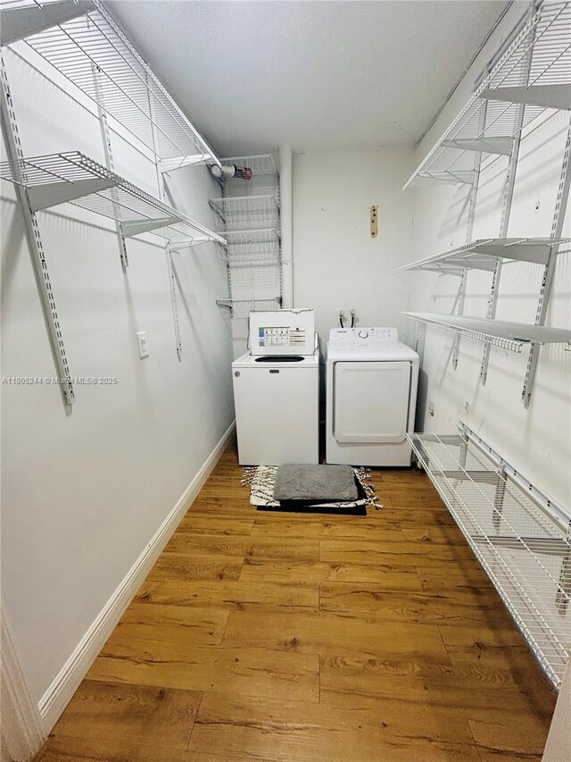 3480 Torremolinos Ave Unit A-33, Doral, FL 33178 - clothes washing area featuring washing machine and clothes dryer, light wood-type flooring, and baseboards