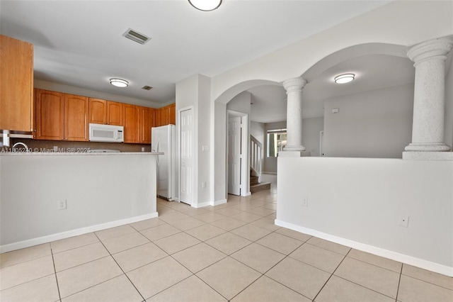 1458 SE 24th Ct Unit 353, Homestead, FL 33035 - kitchen featuring white appliances, ornate columns, arched walkways, and light tile patterned flooring