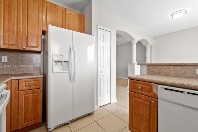 1458 SE 24th Ct Unit 353, Homestead, FL 33035 - kitchen featuring white appliances, light tile patterned floors, backsplash, arched walkways, and light countertops