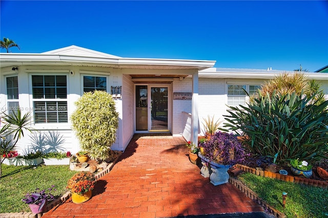entrance to property featuring brick siding