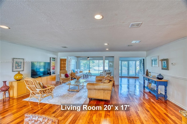 living room with a textured ceiling, wood-type flooring, recessed lighting, and baseboards