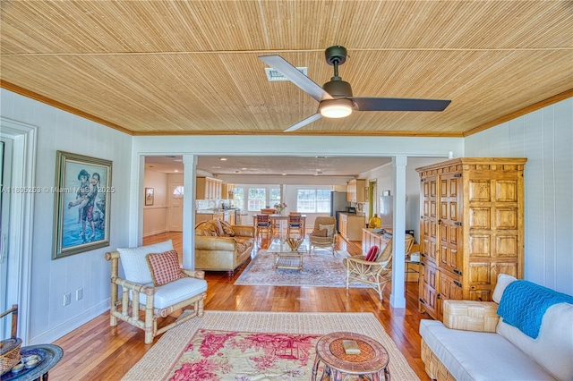 living area featuring decorative columns, crown molding, wooden ceiling, wood finished floors, and a ceiling fan