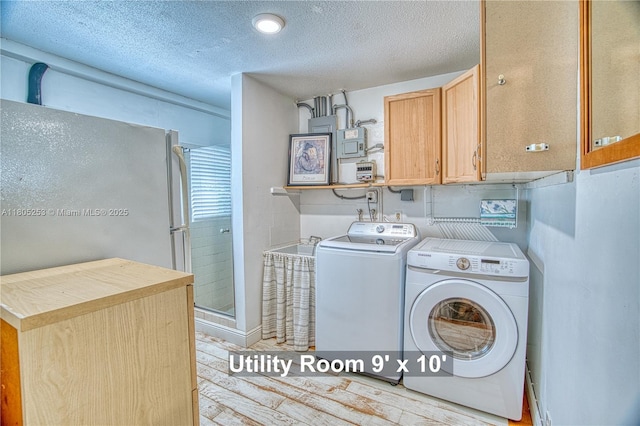 laundry area with separate washer and dryer, a textured ceiling, wood finished floors, and cabinet space