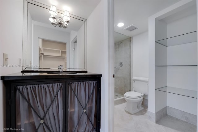 bathroom featuring tile patterned flooring, toilet, vanity, a shower stall, and a chandelier