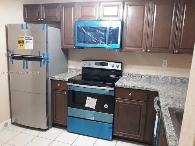 2731 SE 17th Ave Unit 207, Homestead, FL 33035 - kitchen featuring stainless steel appliances, dark brown cabinets, light tile patterned flooring, and a sink