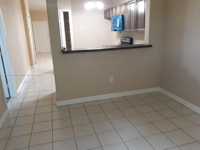 2731 SE 17th Ave Unit 207, Homestead, FL 33035 - kitchen featuring range with electric cooktop, light tile patterned floors, dark countertops, and baseboards
