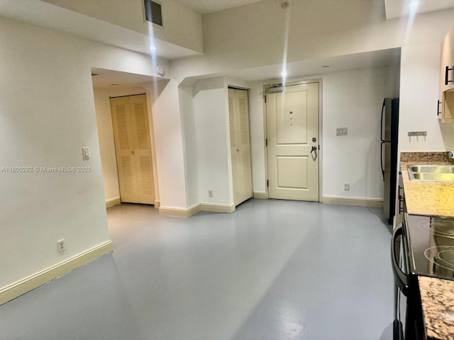 111 E Flagler Unit 702, Miami, FL 33131 - garage with freestanding refrigerator, baseboards, and a sink