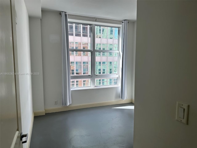 111 E Flagler Unit 702, Miami, FL 33131 - unfurnished room with baseboards and concrete flooring