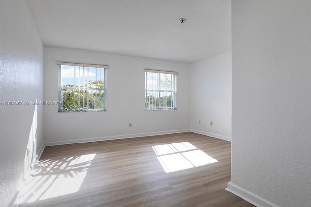 10022 NW 7th St Unit 206, Miami, FL 33172 - empty room with wood finished floors, a textured wall, fire sprinkler in ceiling, and baseboards