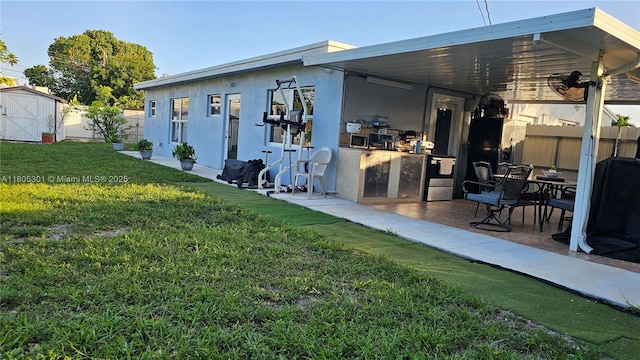 4651 SW 19th St, Fort Lauderdale, FL 33317 - rear view of property featuring a storage unit, an outbuilding, stucco siding, and a patio area