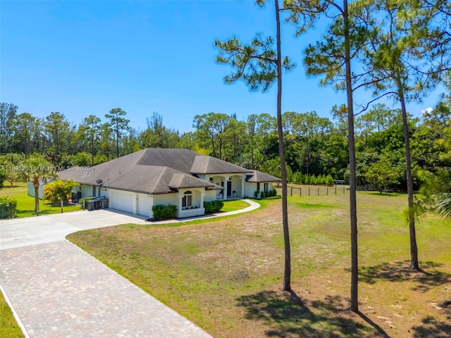 ranch-style home featuring an attached garage, driveway, and a front lawn