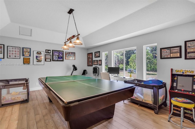 recreation room featuring wood finished floors, baseboards, a desk, and lofted ceiling