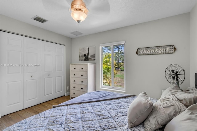 bedroom with wood finished floors, a closet, and a ceiling fan