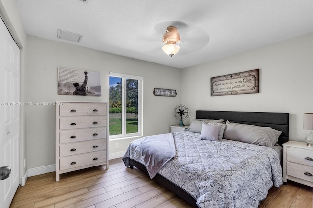 bedroom with light wood-style flooring, baseboards, a closet, and ceiling fan