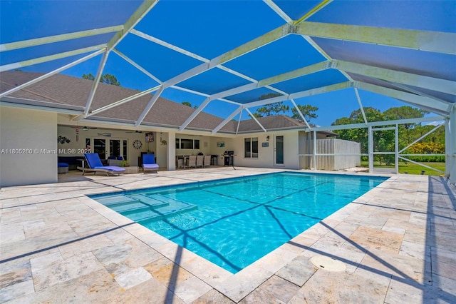 outdoor pool with a patio area, ceiling fan, and glass enclosure